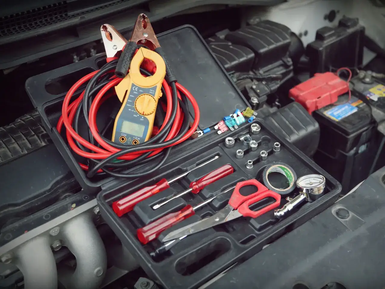 Herramientas para revisar la bater&iacute;a del coche, como pinzas y mult&iacute;metro, para saber cuanto dura una bateria de coche.