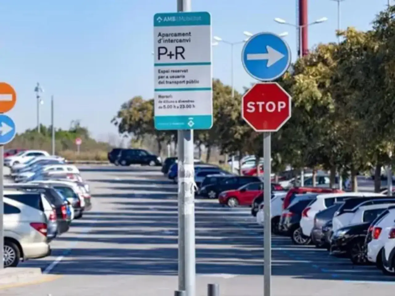 Aparcament d'intercanvi P+R, ideal para parking gratuit Barcelona. Señal de STOP y flecha azul indican la dirección.