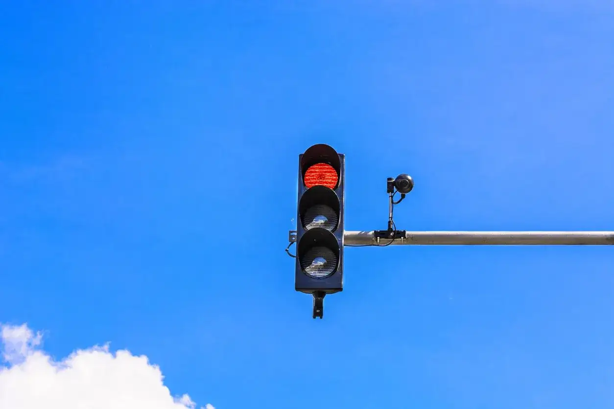 Sem&aacute;foro en rojo con c&aacute;mara, &iexcl;cuidado con la multa sem&aacute;foro rojo! Cielo azul despejado.